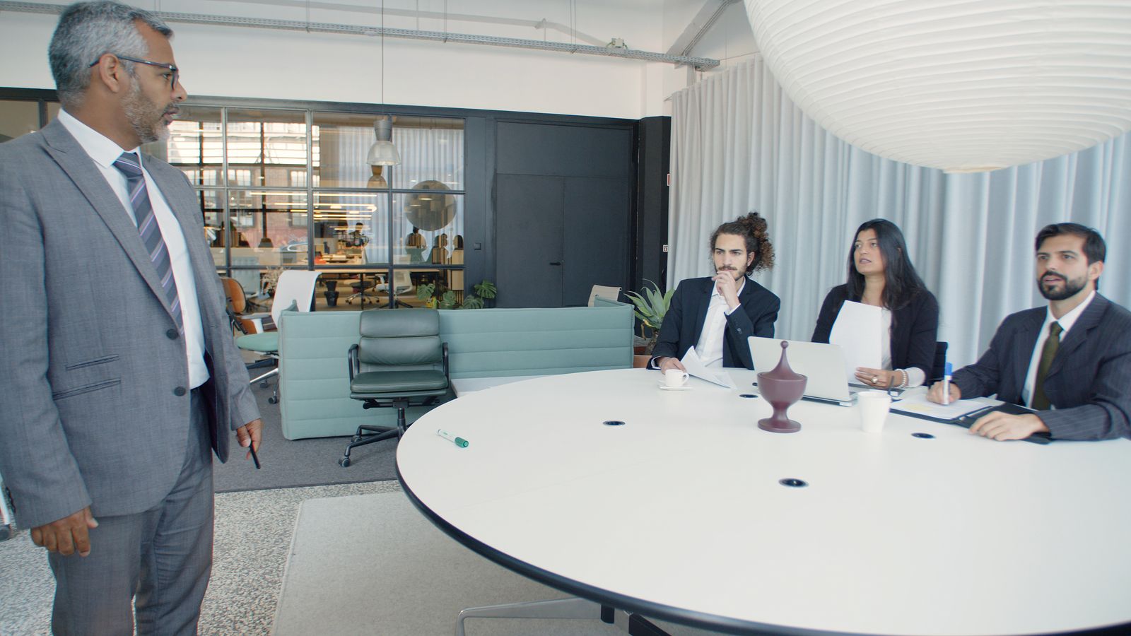 A business meeting around a conference table in a bright office